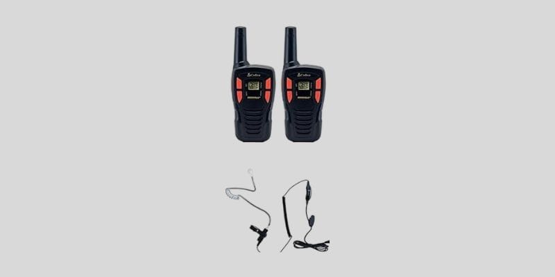 Cobra ACXT145 compact long range walkie talkies 1000 miles with black/orange surveillance headset, featuring 22 channels, rechargeable batteries, and tactical communication gear.